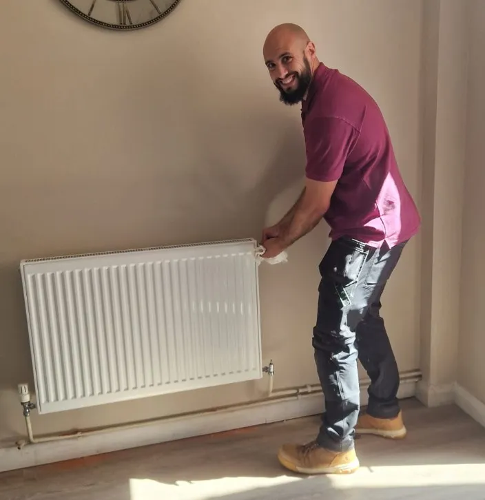 James Mitson from Gold Wrench Property Services fitting a radiator in a customer's home